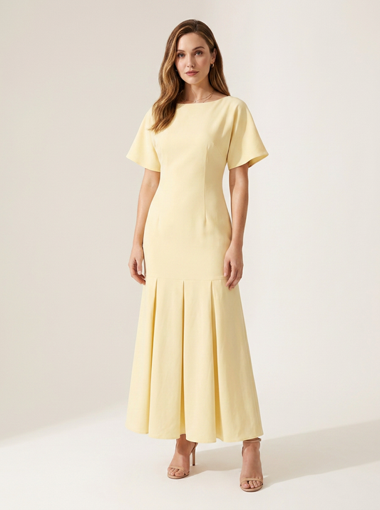 A woman modeling a pale yellow midi dress with short flutter sleeves, a boat neckline, and a flared skirt, photographed against a plain light beige studio background.