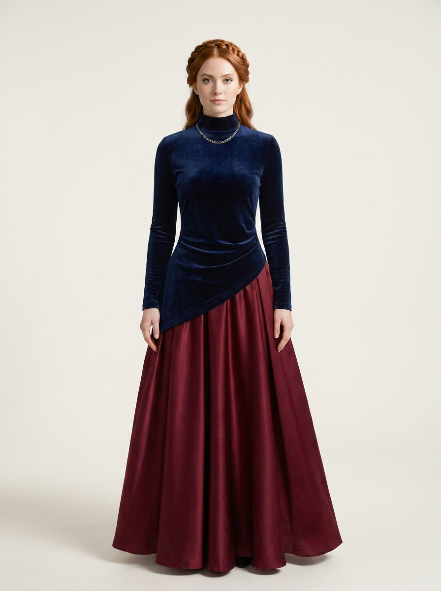 A woman stands against a plain light beige studio background wearing a long-sleeve velvet top with an asymmetrical hem in dark navy blue and a full satin skirt in deep burgundy.
