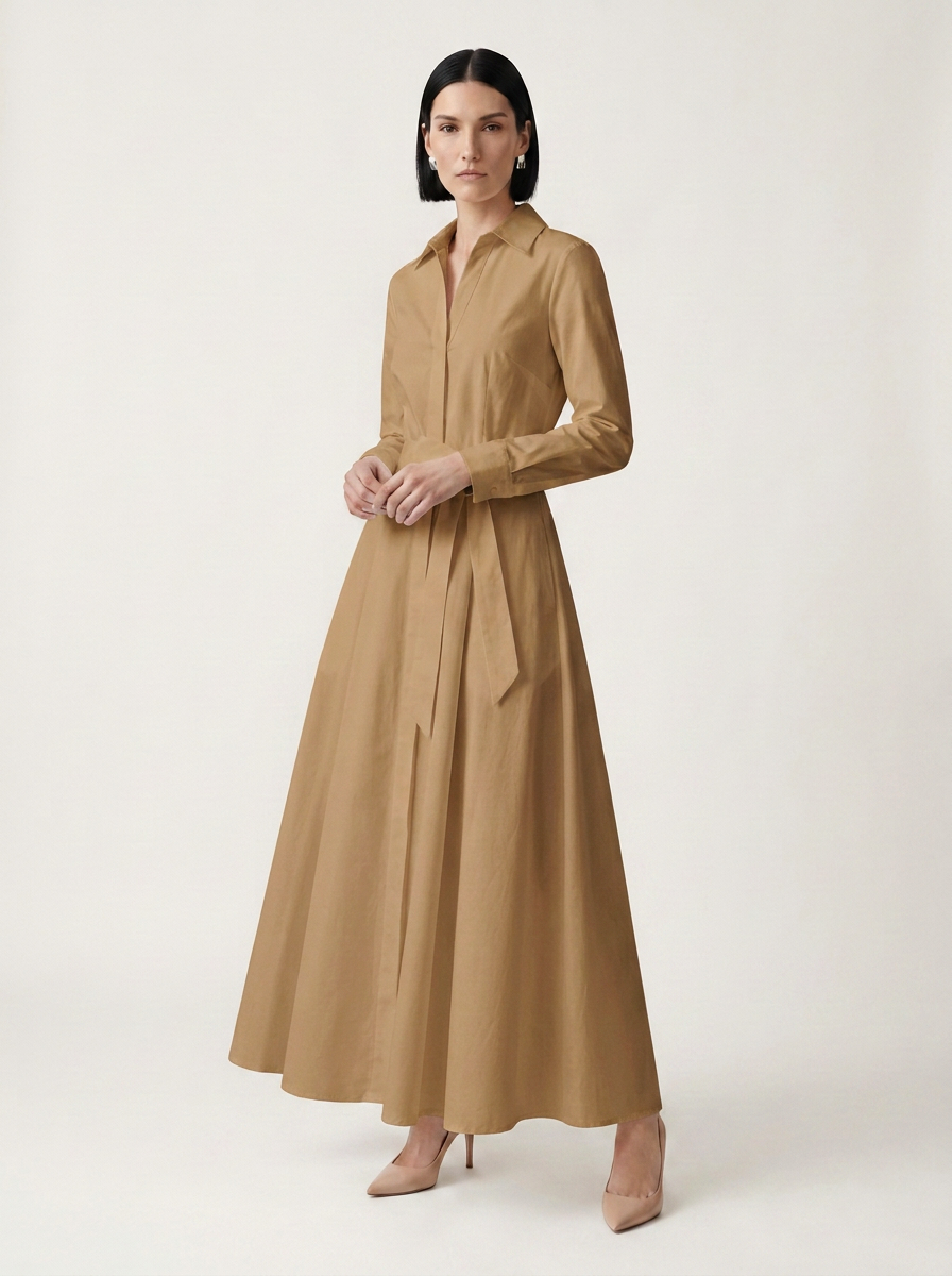 A woman modeling a long-sleeved, collared maxi shirt dress in camel brown against a plain, light beige studio background.