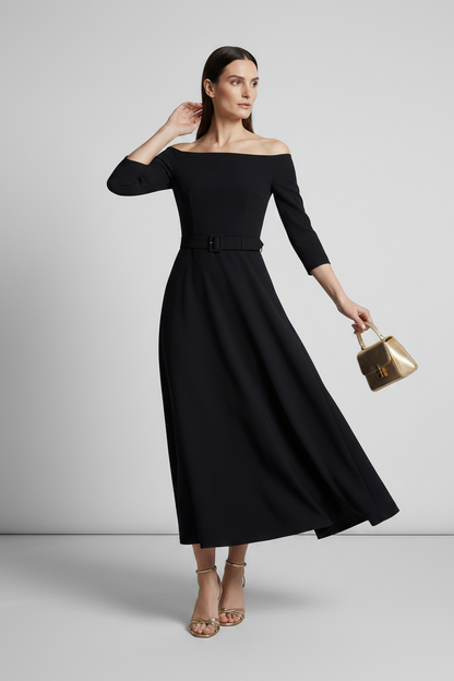 A woman modeling an off-the-shoulder black midi dress with three-quarter sleeves and a matching black belt. She is holding a small gold handbag and wearing gold heeled sandals, set against a plain light gray studio background.