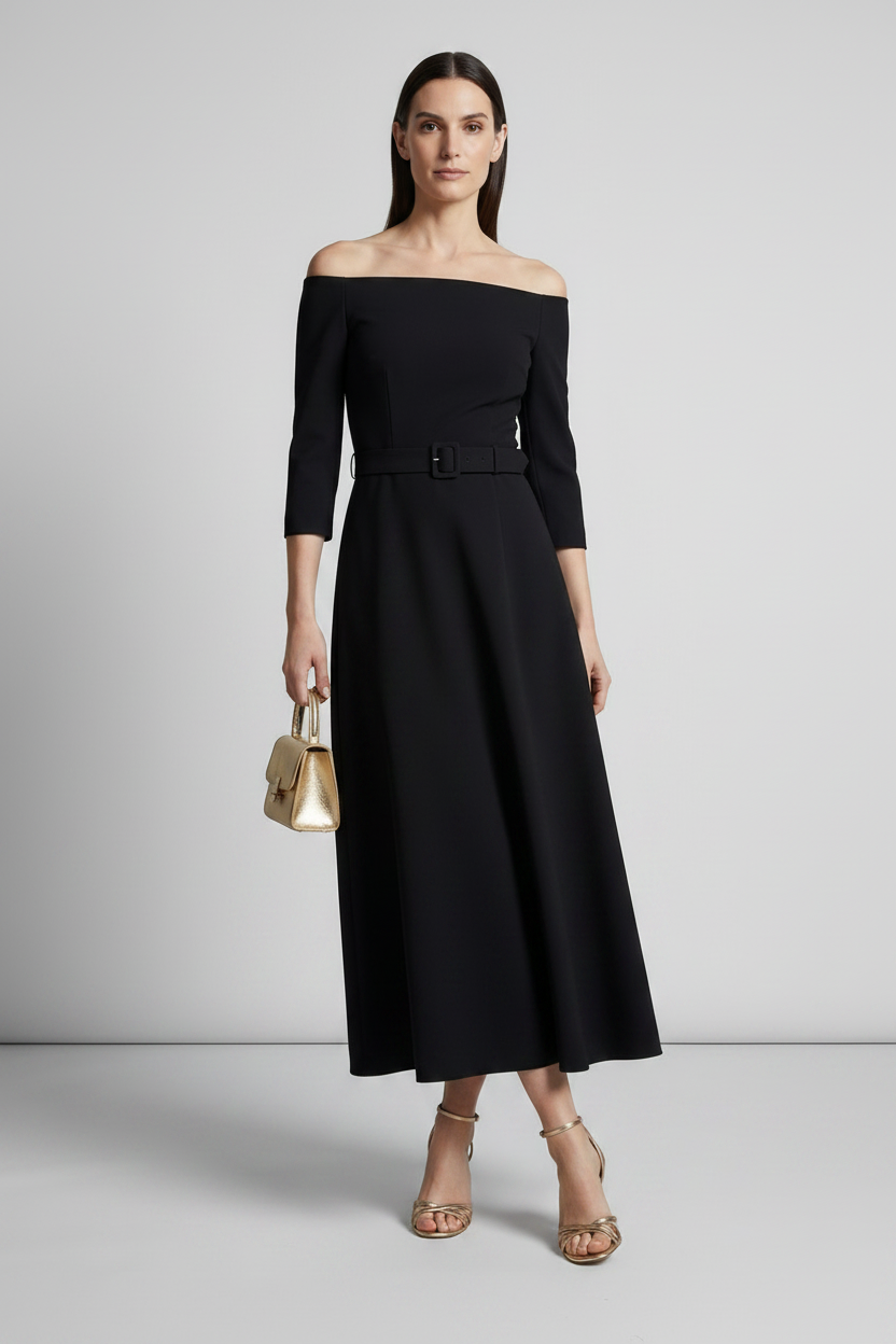 A woman models an off-the-shoulder black midi dress with three-quarter sleeves and a matching belt. She is holding a small metallic gold handbag and wearing gold strappy heels, set against a neutral light gray studio background.