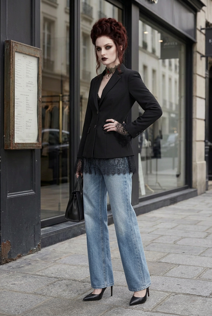 A model stands on a city sidewalk wearing a black blazer, wide-leg light blue jeans, black lace-trimmed gloves, a black choker, and black heels, holding a black handbag.
