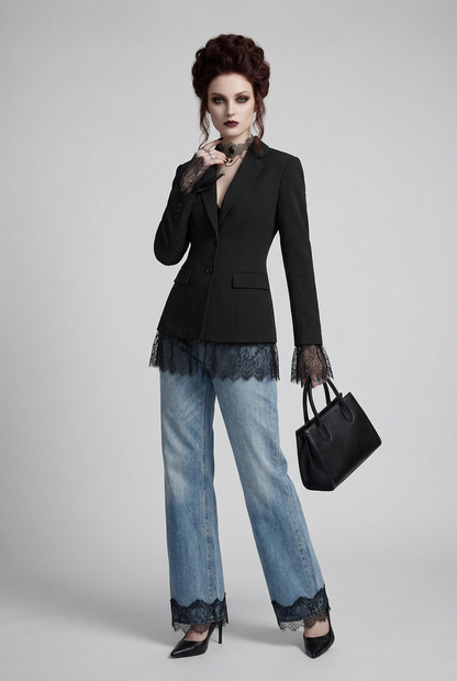 A model stands against a light gray studio background wearing a black tailored blazer with sheer lace cuffs, light blue wide-leg jeans, black heels, and holding a black handbag.